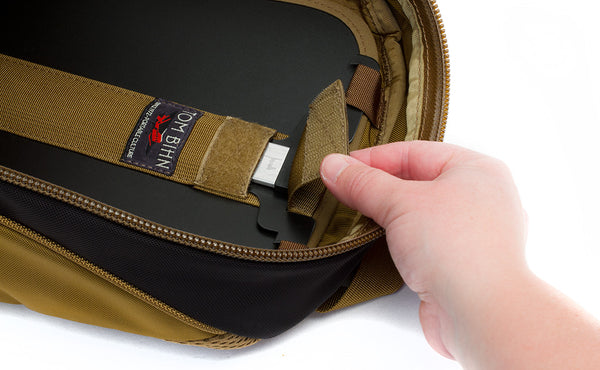 A person closing the pull tab of the removeable frame sheet over the t-bar and aluminum center stay to lock it in place inside the Guide's Edition Synapse 25.